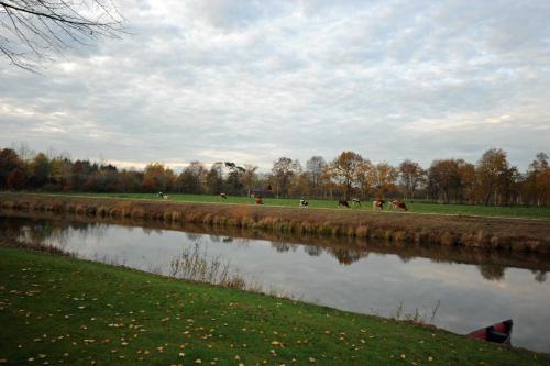 a river with a group of people walking along it at Ferienwohnung Schilling_ 65043 in Moormerland