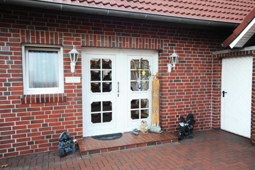 a brick house with a white door and windows at Ferienwohnung Schilling_ 65043 in Moormerland