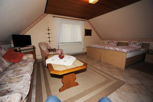 ein Wohnzimmer mit 2 Betten und einem Tisch in der Unterkunft Ferienwohnung Schilling, 65043 in Moormerland