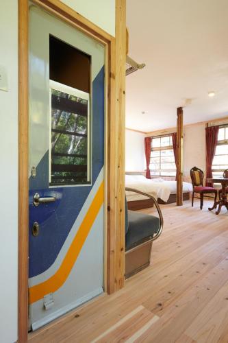 a room with a blue and yellow door and a bedroom at Nipponia Hotel Koyasan Pilgrimage Railway - In the station Inn - Self Check-In Only in Kudoyama