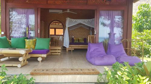 a living room with purple and green pillows at Good Karma Bungalows in Amed