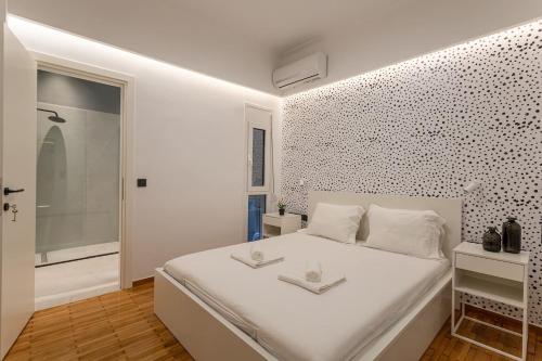 a white bedroom with a large white bed and a bathroom at Luxury Penthouse on Akadimias with 2 Bed & 2 Bath in Athens