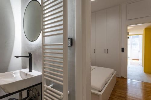 a bathroom with a sink and a mirror and a bed at Luxury Penthouse on Akadimias with 2 Bed & 2 Bath in Athens