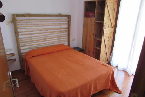 - une chambre avec un lit et une couverture orange dans l'établissement CASA ANE, à Biescas