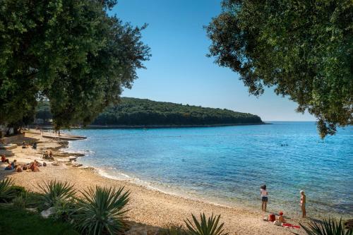 a group of people on a beach near the water at Maistra Camping Porto Sole Mobile homes in Vrsar