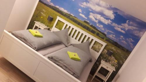 ゼーバハにあるFerien im Schwarzwaldのベッド1台、枕、壁画が備わる客室です。