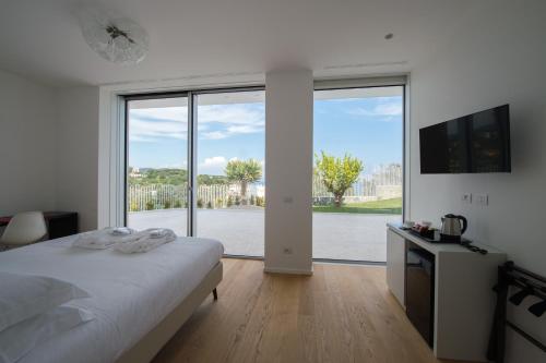 - une chambre avec un lit et une grande fenêtre dans l'établissement Capo Torre Resort & SPA, à Albisola Superiore