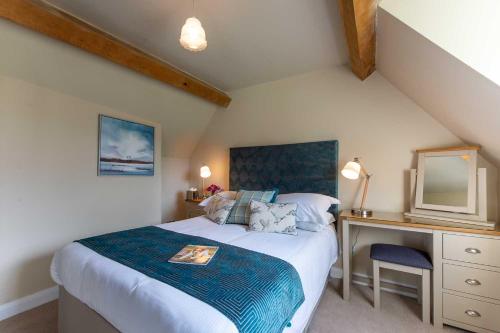 a bedroom with a bed and a desk with a television at The Dinney B&B in Bridgnorth