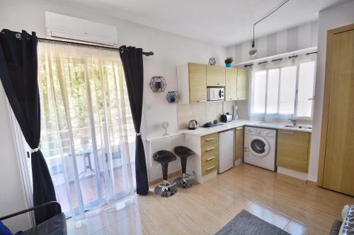 a kitchen with a sink and a washing machine at PMP Adamia Apartments in Peyia