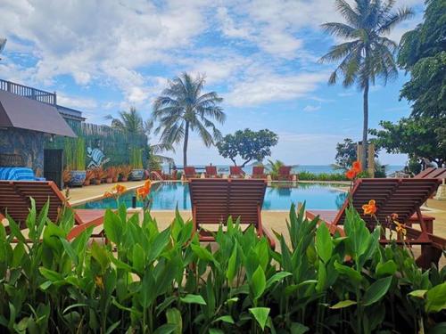 un complejo con piscina, sillas y palmeras en Kao Tao Villa Beach Resort en Ban Khao Tao