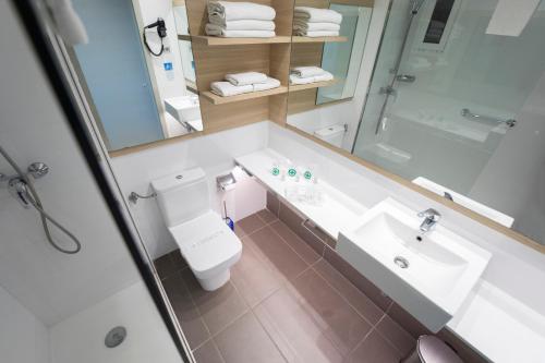a bathroom with a toilet and a sink and a shower at Hotel Cesar Augustus in Cambrils