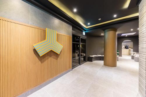 a lobby with a yellow and blue sign on a wall at Brown Dot Hotel Seong Seo in Daegu