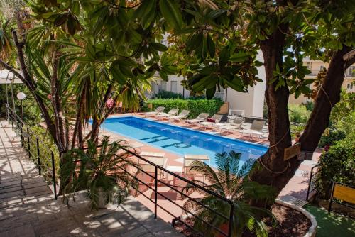 a swimming pool in a yard with trees at Hotel Principe in Sanremo