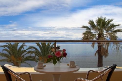 a table with a vase of flowers on a balcony at Hotel Coral Beach in Roda