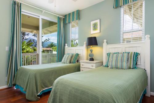 two beds in a room with a balcony at Nihilani 25C in Princeville