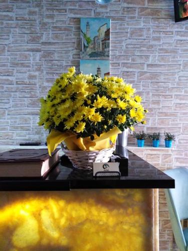 a vase filled with yellow flowers on a table at Atlas City Center Hotel in Prilep
