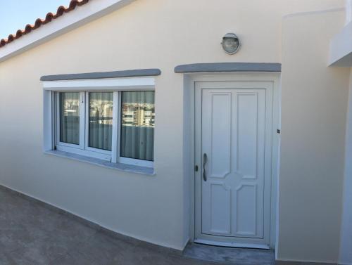 una casa bianca con una porta e due finestre di Sunny Elegant Studio ad Atene