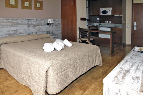 a bedroom with a bed with two pillows on it at Aparthotel La Vall Blanca in Vielha