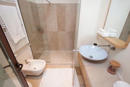 a bathroom with a shower and a sink and a toilet at La Sommità Relais & Chateaux in Ostuni
