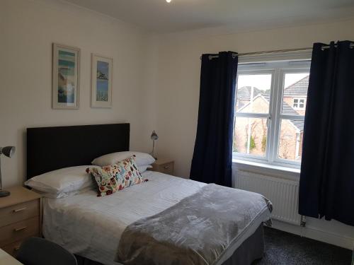 a bedroom with a bed and a large window at Home2Home Meadow Close in East Kilbride