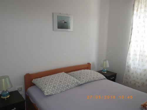 a bedroom with a bed with two night stands and two lamps at Apartments Mir - perfect location & cosy in Korčula
