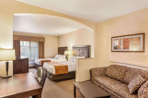 Comfort Suites Moses Lake في موسيس ليك: غرفه فندقيه بسرير واريكه