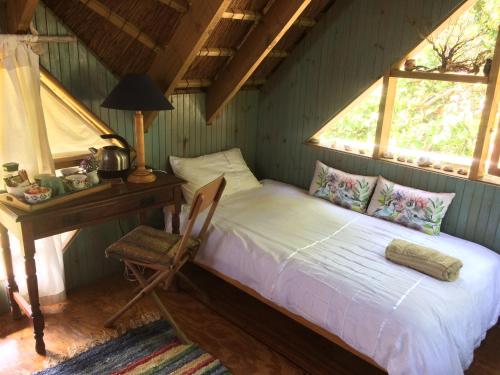 מיטה או מיטות בחדר ב-Driftwood Treehouse