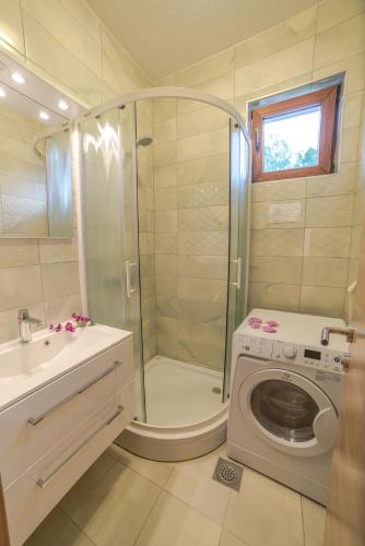 a bathroom with a shower and a washing machine at Grand Apartments-For Groups in Sarajevo
