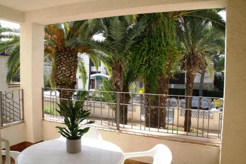 a balcony with a table and palm trees at Apartaments Ocean Canada in Platja d'Aro