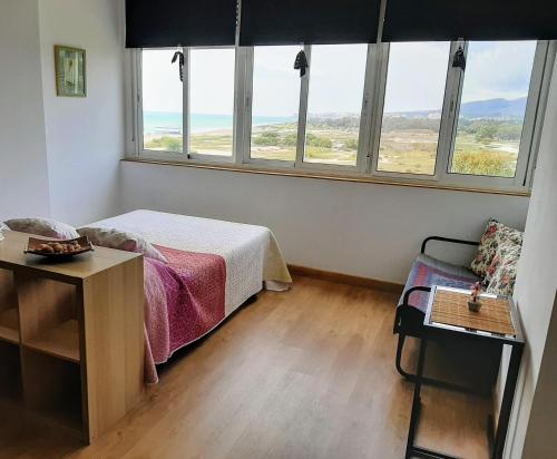 a bedroom with a bed and a table and windows at Sunny Beach in Málaga