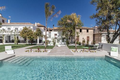 a swimming pool in front of a house at Finca Casabela in Pinos del Valle