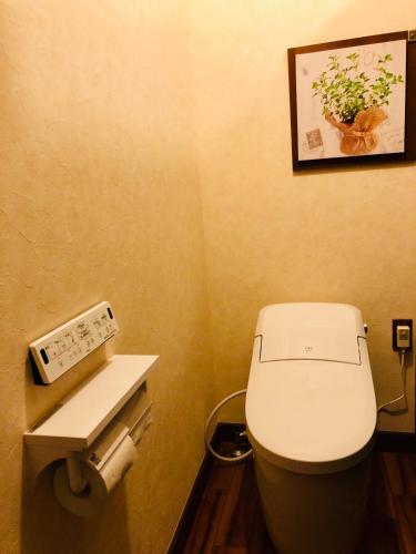 a small bathroom with a toilet and a picture on the wall at The Guest House Japan Hakuba in Hakuba