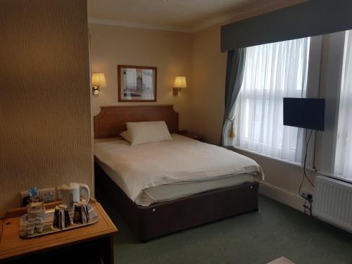 Habitación de hotel con cama y ventana en Welbeck Hotel & Apartments, en Douglas
