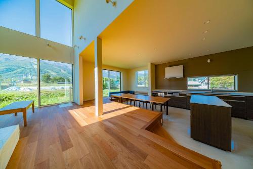 a large room with wooden floors and large windows at Bikei Chalet by Hakuba White Fox Company in Hakuba