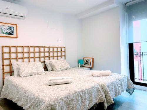 biała sypialnia z dużym łóżkiem z białą pościelą w obiekcie Casa Ribera Lucano Centro Historico w Kordobie