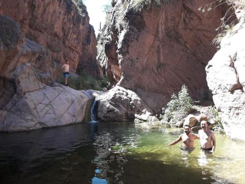 two people standing in the water in a canyon at Hospedaje Familiar Raza Mistica in Villa Unión