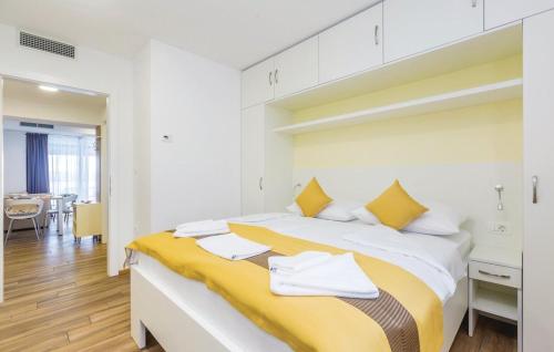 a white bedroom with a yellow and white bed at Vila Ponte in Punat