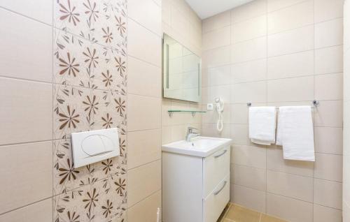 a white bathroom with a sink and a mirror at Vila Ponte in Punat