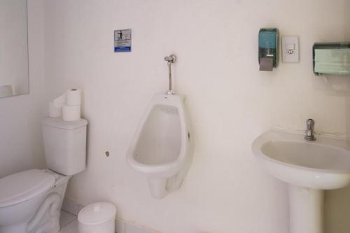 baño con urinario, aseo y lavamanos en Arena Maracanã Hostel, en Río de Janeiro