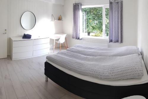 1 dormitorio con cama, escritorio y espejo en I hjerte av Åndalsnes sentrum, en Åndalsnes