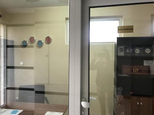 a glass door in a room with clocks on the wall at BLOCK 531 ApartHouse BLOCK 533 in Sofia