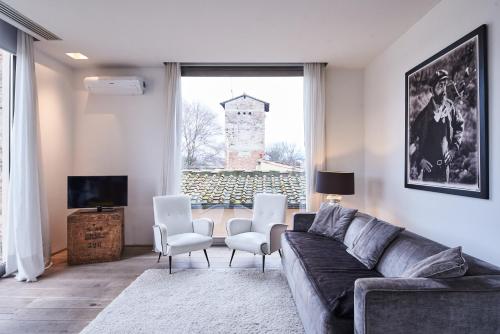a living room with a couch and chairs and a window at Riva Lofts Florence in Florence