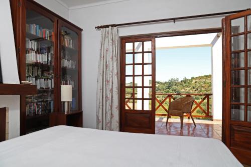 a bedroom with a bed and a large window at Casa do Vale Paraíso - Piscina e Court de Ténis a 30 min de Lisboa in Vale do Paraíso
