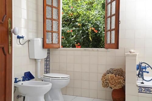 a bathroom with a toilet and a window at Casa do Vale Paraíso - Piscina e Court de Ténis a 30 min de Lisboa in Vale do Paraíso
