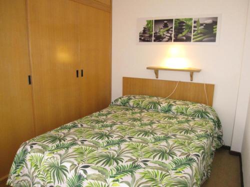 a bedroom with a bed with a green and white blanket at Appartamento Ariston in Lido