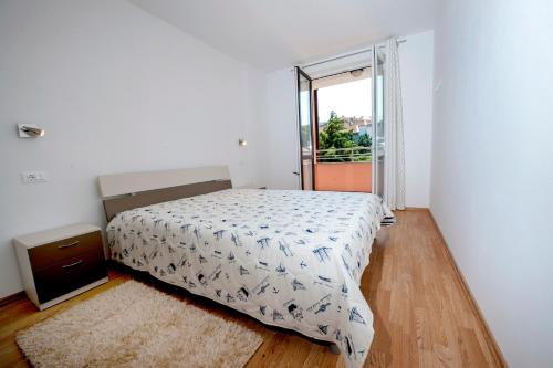 a bedroom with a bed and a large window at Apartments Centener in Rovinj
