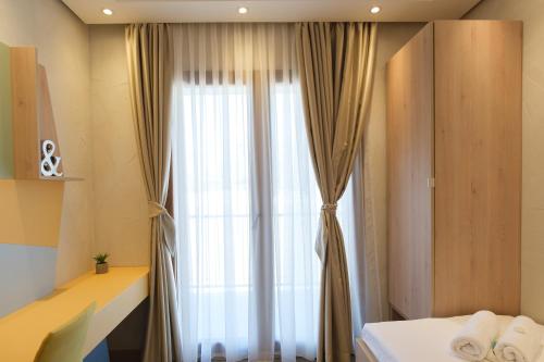 a bedroom with a large window with curtains at Grad Sunca Resort in Trebinje