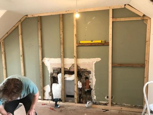 a man constructing a wall in a room at “A Wee Pad in Dunfermline” in Dunfermline
