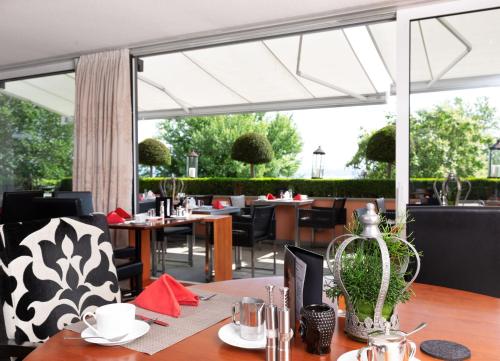 a restaurant with tables and chairs and a large window at Romantik Hotel Residenz am See in Meersburg