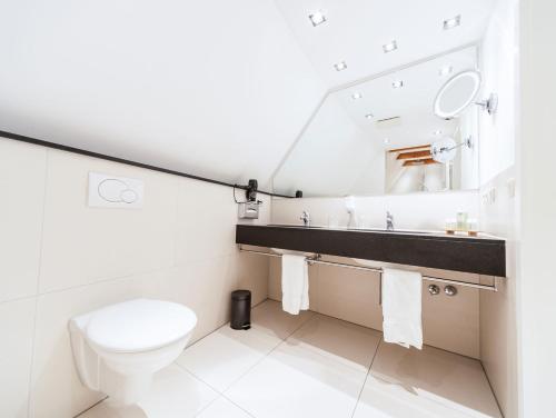 a bathroom with a toilet and a sink at Romantik Hotel Walhalla in Osnabrück